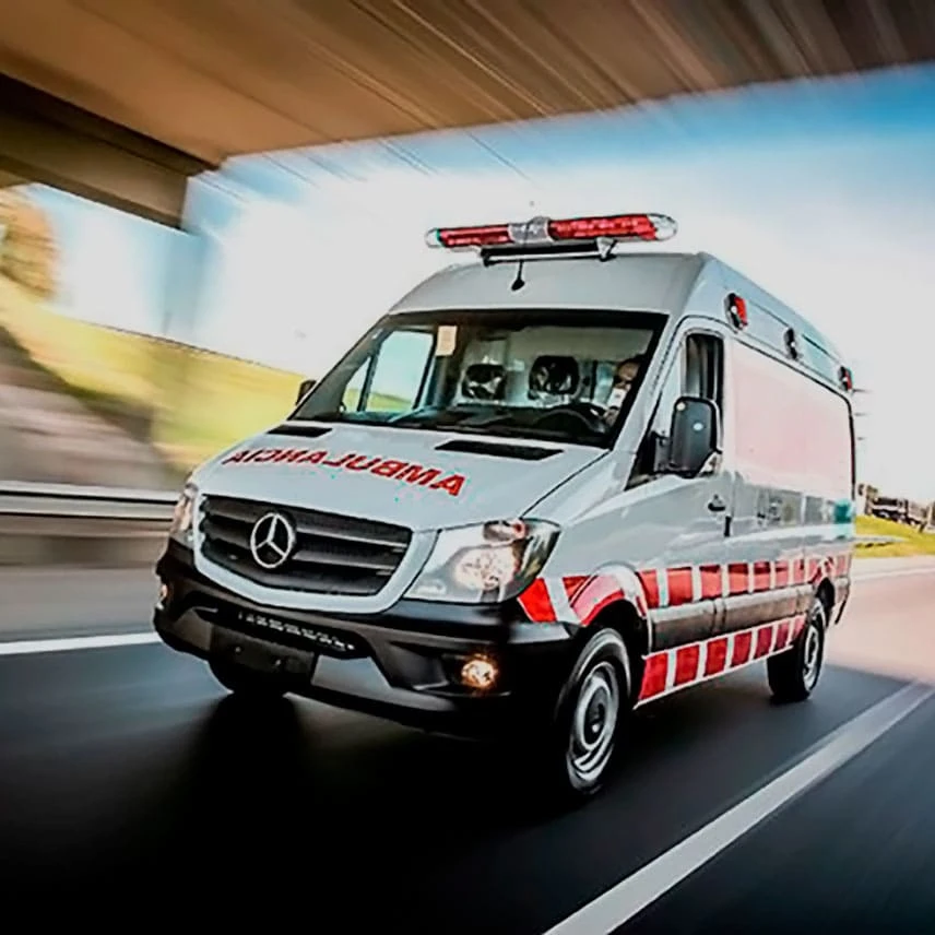 Uma ambulância branca e vermelha em movimento.